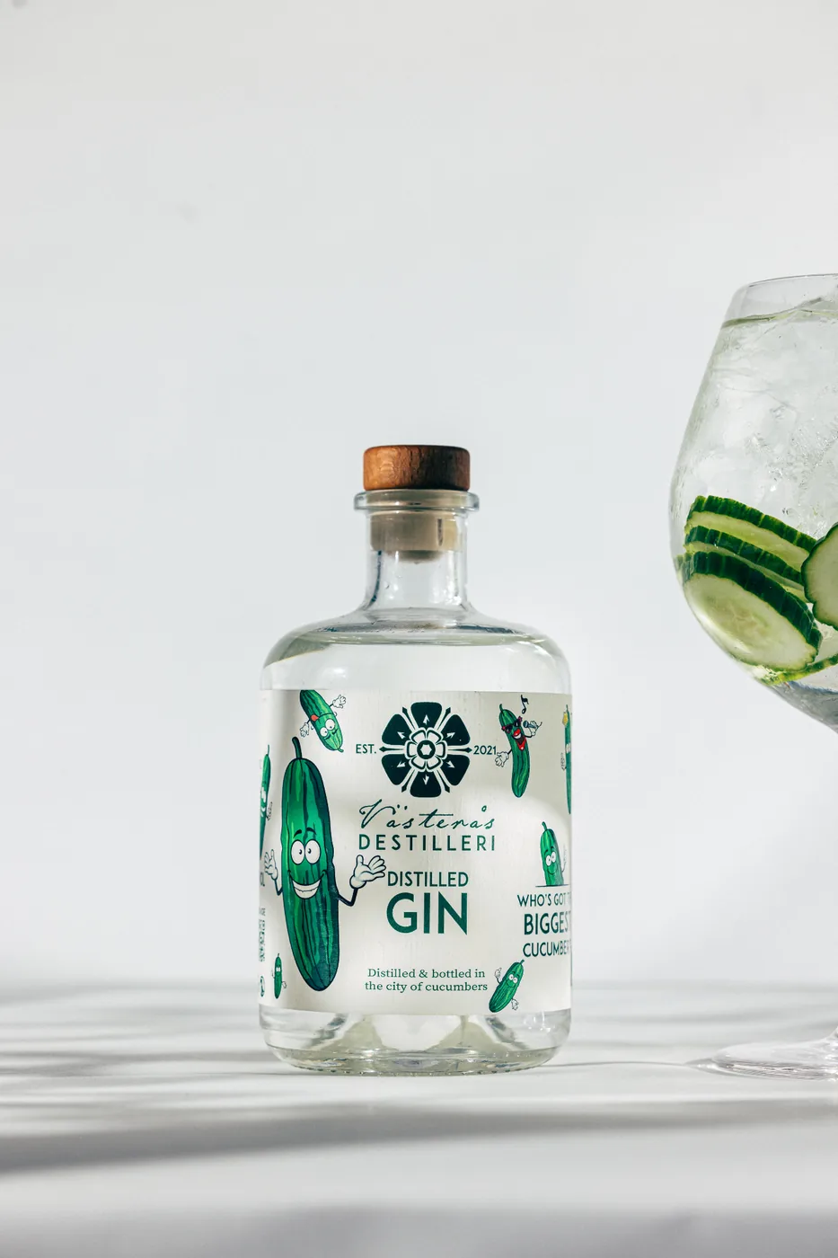 Distilled Gin-flaska bredvid gin & tonic med gurka