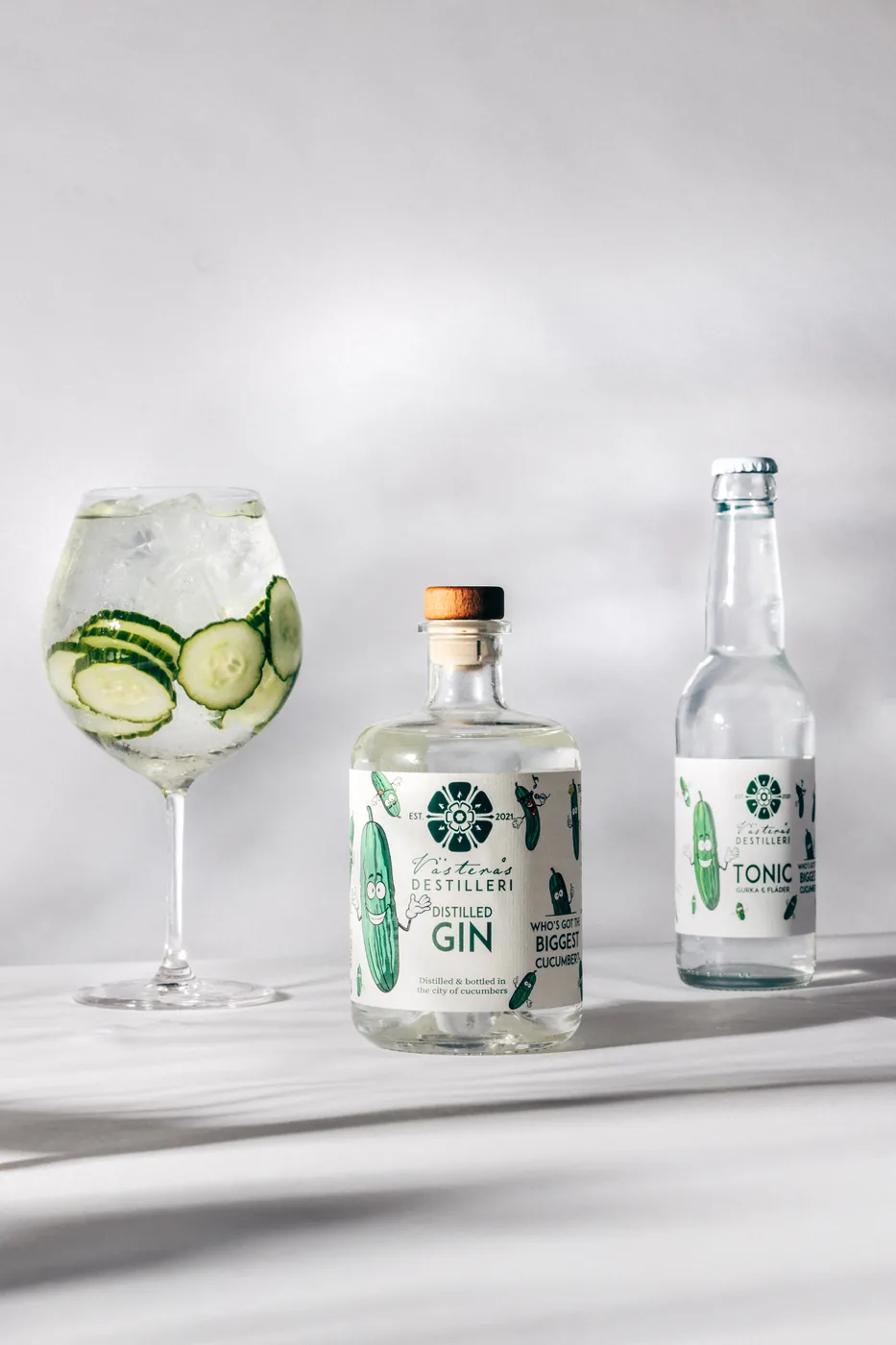 Distilled Gin, gin & tonic och tonicflaska i ljus studiomiljö